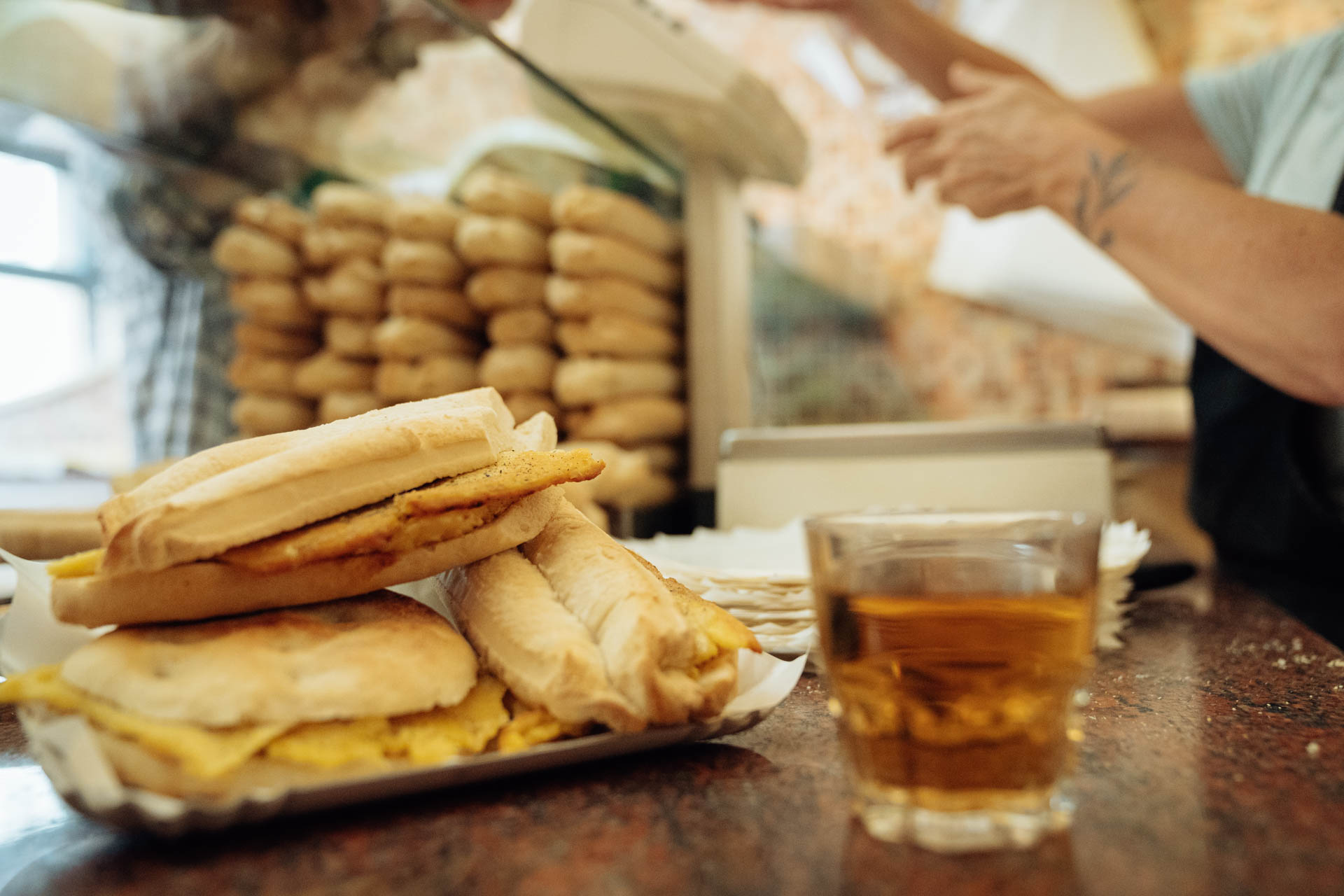 Nell'immagine panini con torta di ceci e bicchiere di spuma bionda